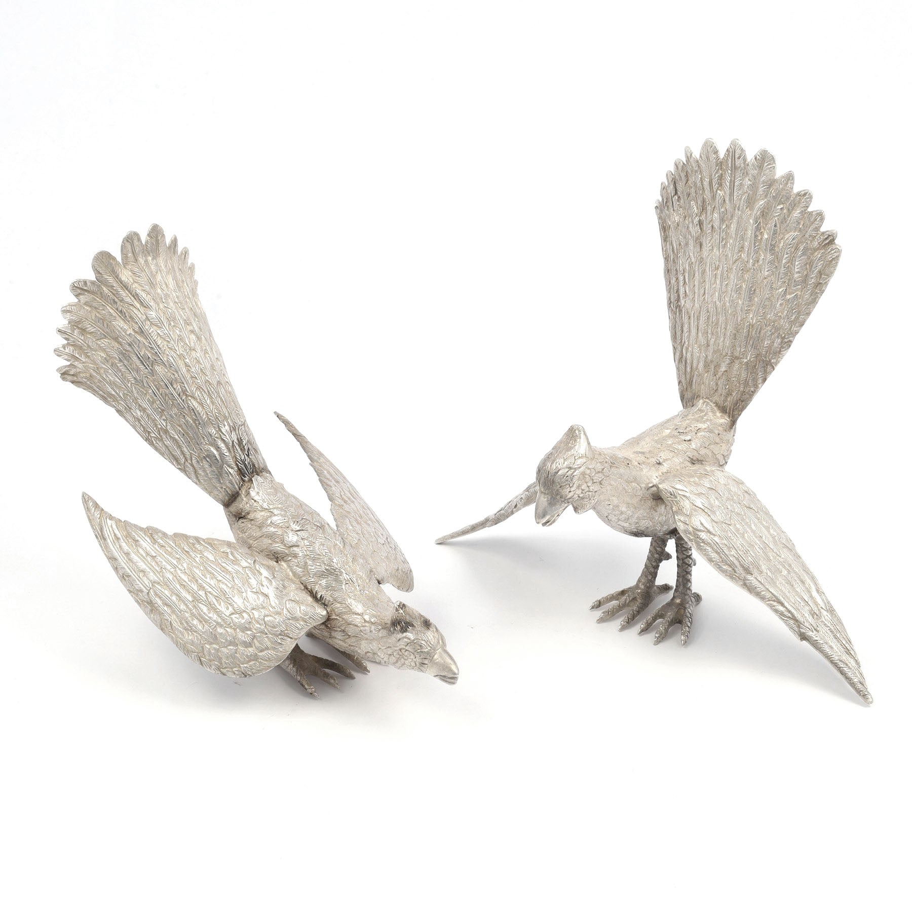 Two silver bird sculptures on a white background
