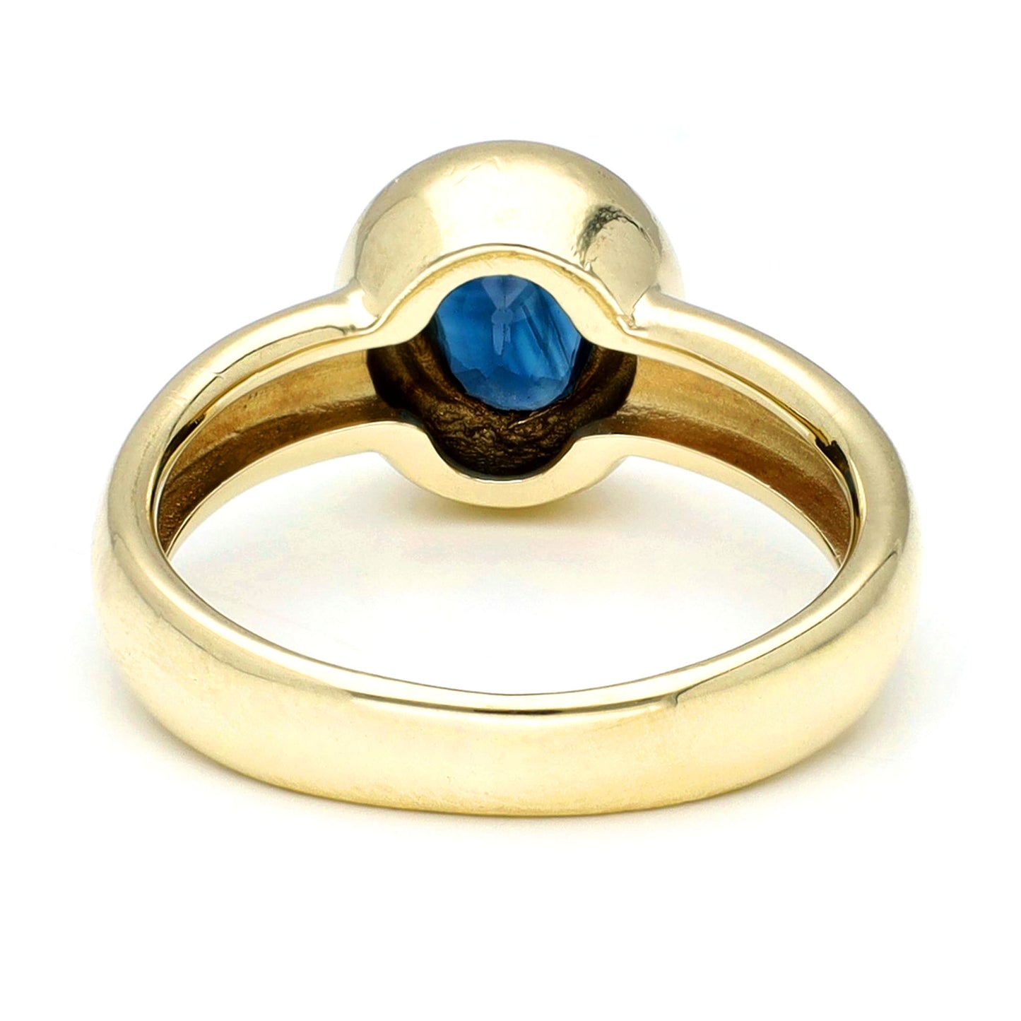 Yellow gold ring with a solitaire oval sapphire, against a white background