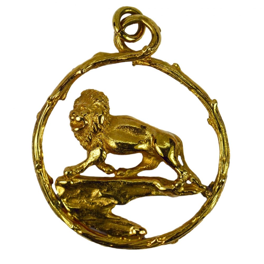 18ct Yellow Gold Lion Charm Pendant; designed as a lion atop a rock within a textured circle representing the Zodiac sign of Leo, London 1959