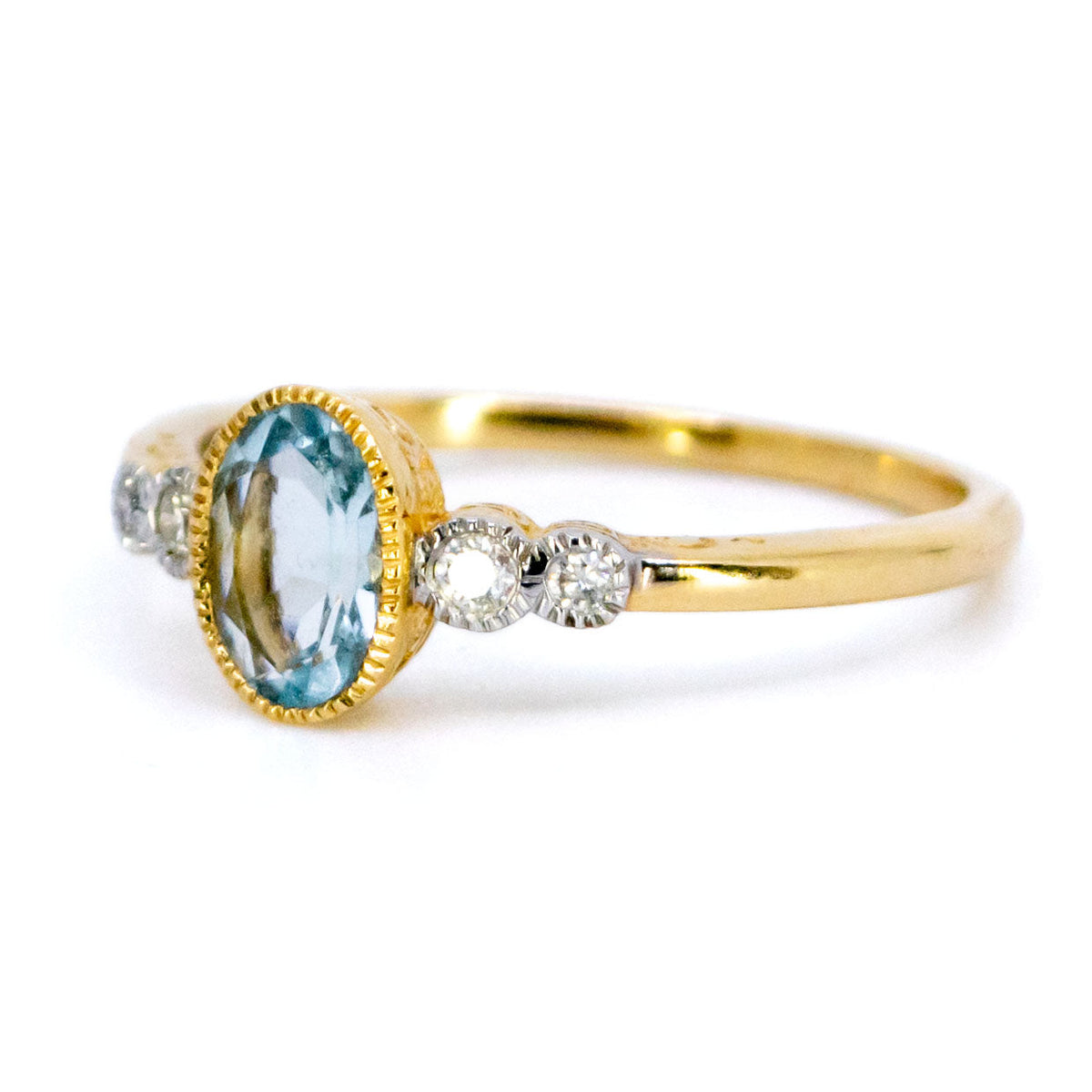 An oval aquamarine and round diamond ring in yellow and white gold