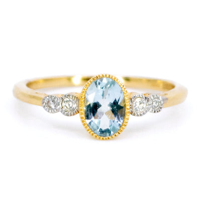 An oval aquamarine and round diamond ring in yellow and white gold