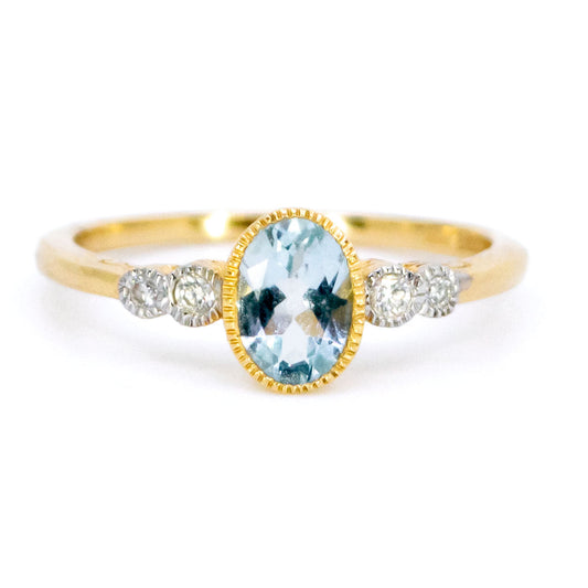 An oval aquamarine and round diamond ring in yellow and white gold