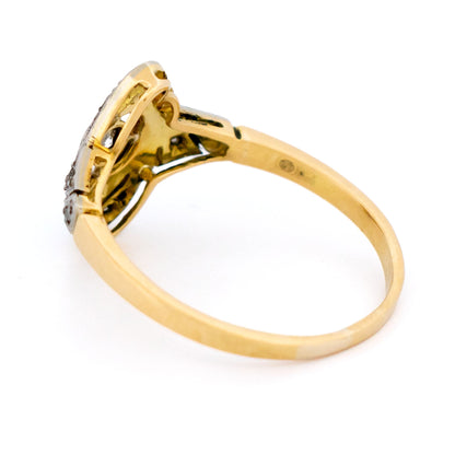 A yellow gold and platinum swirl design ring with diamonds
