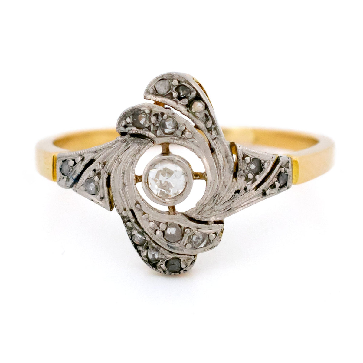 A yellow gold and platinum swirl design ring with diamonds