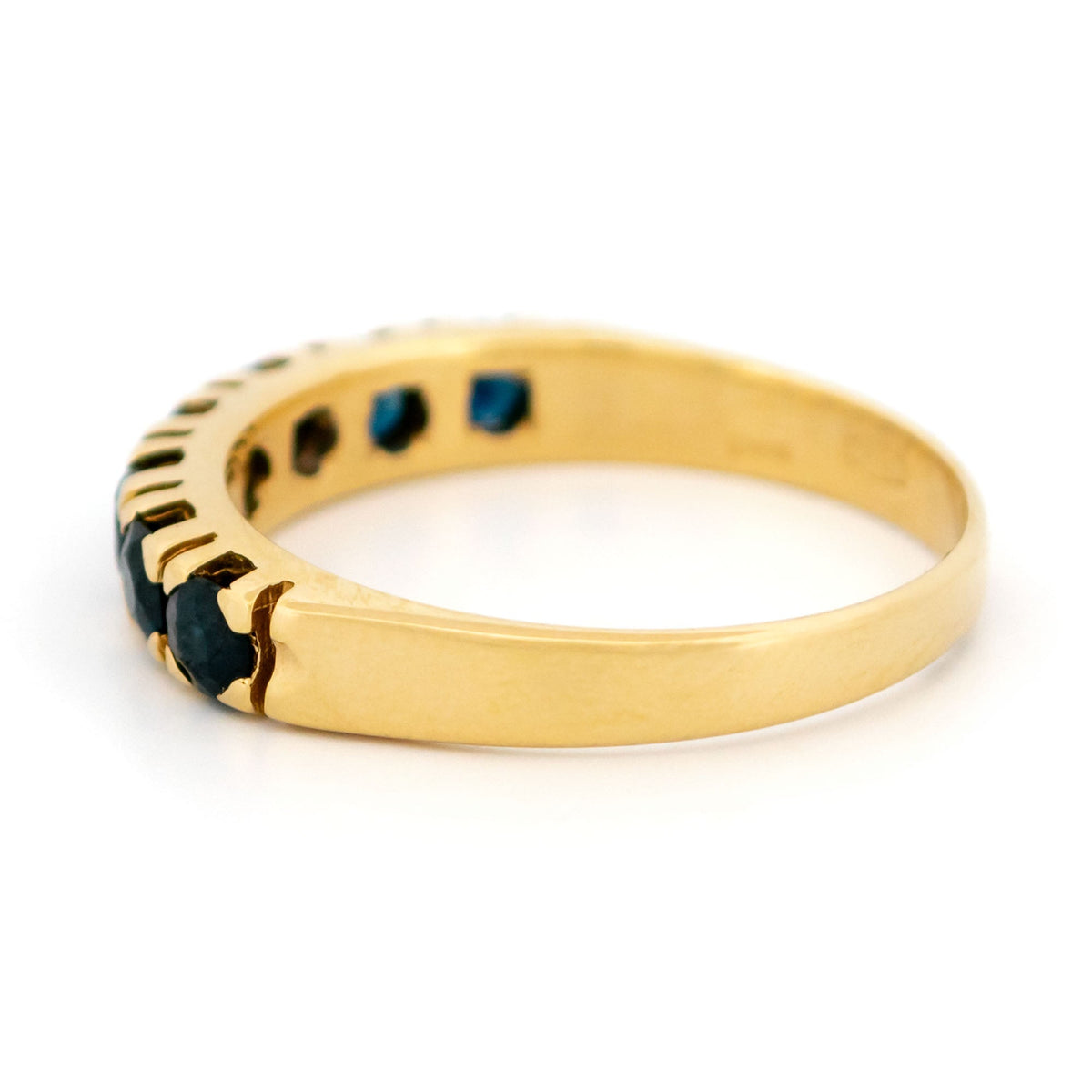 A seven stone round sapphire band ring in yellow gold
