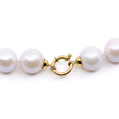 A white cultured pearl necklace, with a yellow gold clasp