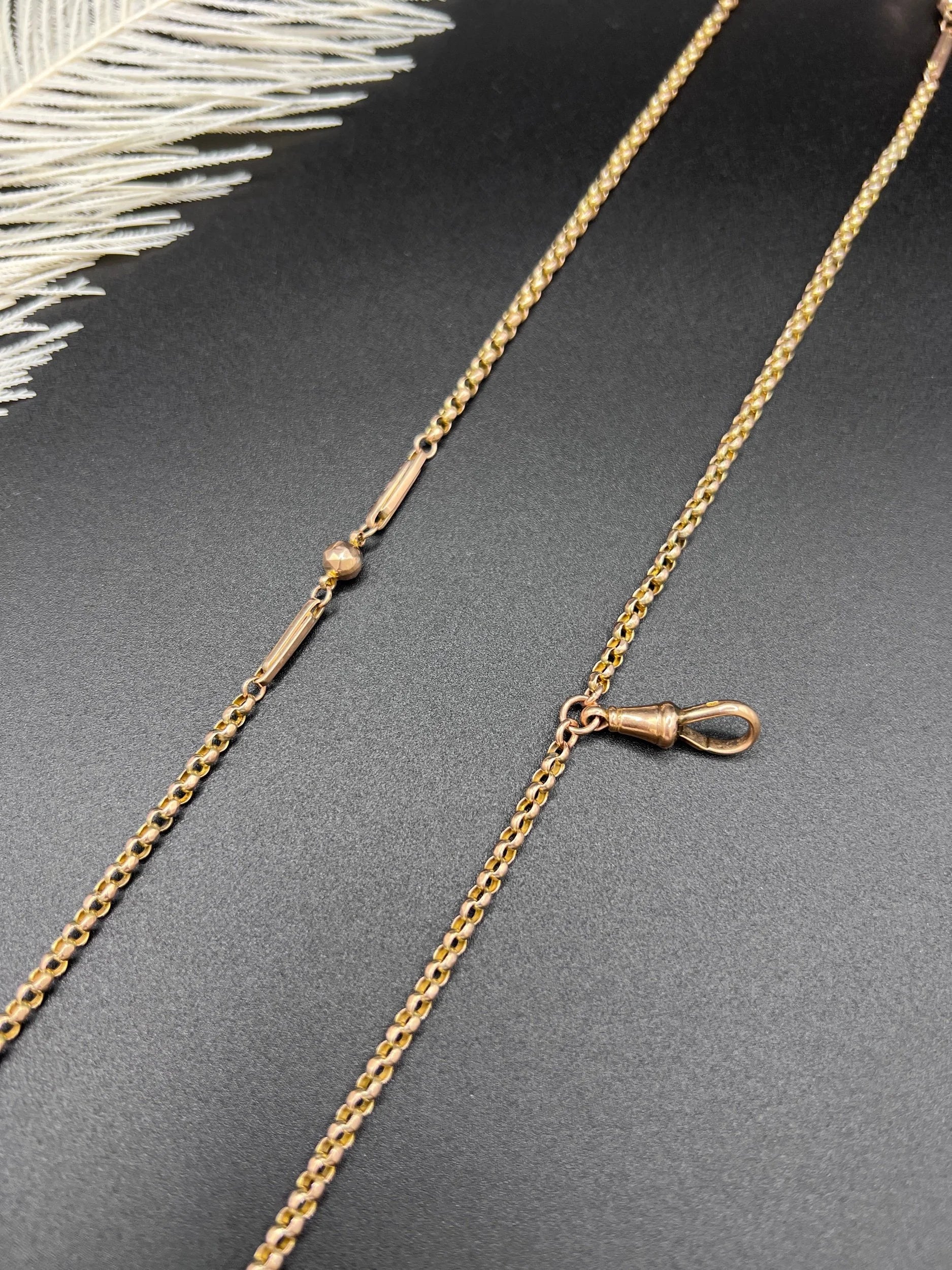A long rose gold chain necklace with a dog clip clasp