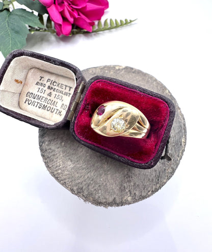 A yellow gold double headed snake ring with a ruby and a diamond, in a ring box