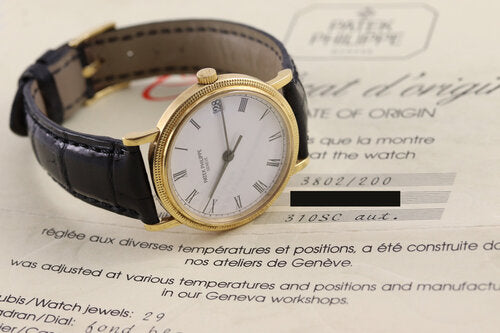 Patek Philippe 3802 Calatrava 18ct Yellow Gold 33mm Automatic, porcelain white dial, Roman numerals, date indicator at 3, calibre 310SC, Patek Phillipe black leather strap with 18ct Yellow Gold buckle, Circa 1991, in mint condition, with Patek Philippe pouch and papers.