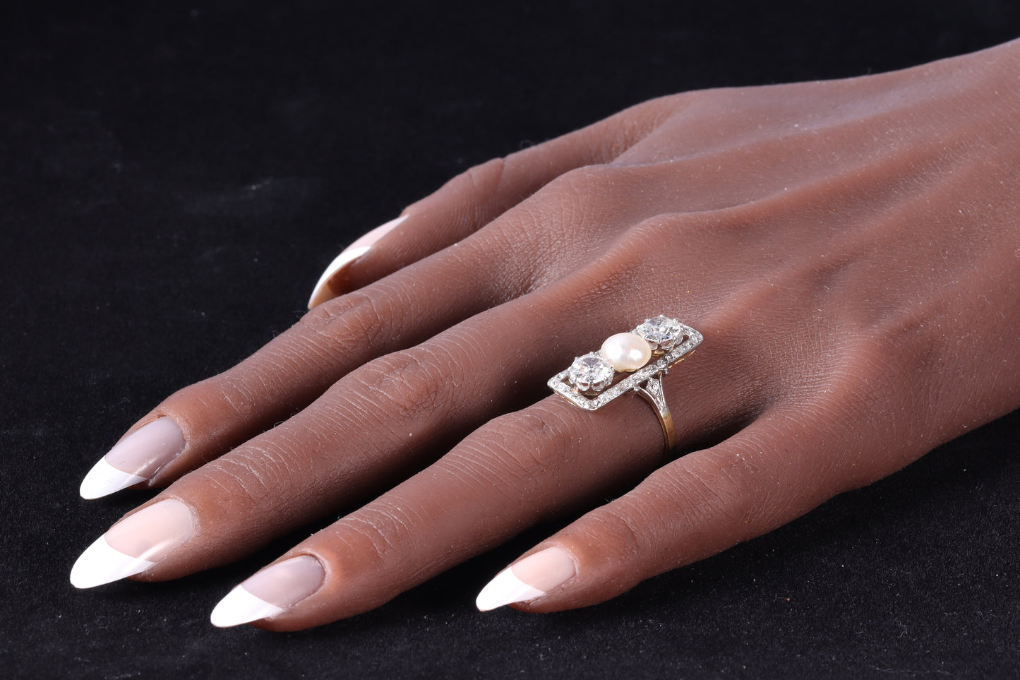 A diamond and pearl elongated plaque ring in yellow gold and platinum modelled on a hand