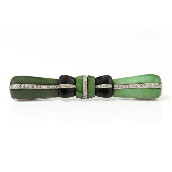 Art Deco Jadeite, Onyx and Old Cut Diamond Bow Brooch in Platinum; set with jadeite accented with onyx and 0.50cts old-cut diamonds, Circa 1920s