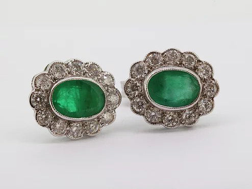 Emerald and Diamond Oval Cluster Stud Earrings; 1.66cts oval faceted emeralds surrounded by 0.80cts sparkling diamonds, in 18ct white gold
