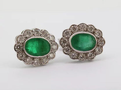 Emerald and Diamond Oval Cluster Stud Earrings; 1.66cts oval faceted emeralds surrounded by 0.80cts sparkling diamonds, in 18ct white gold