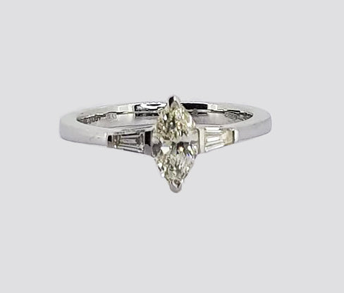 0.57ct Marquise Cut Diamond Engagement Ring; 0.57 carat marquise-cut diamond flanked by 0.21cts tapered baguette-cut diamonds, in 18ct white gold
