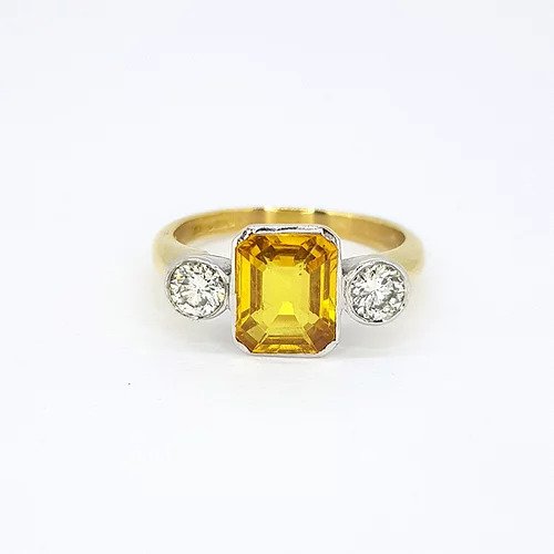 2.25ct Emerald Cut Yellow Sapphire and Diamond Three Stone Ring; central 2.25ct emerald-cut yellow sapphire flanked by 0.50cts brilliant-cut diamonds, 18ct yellow gold shank