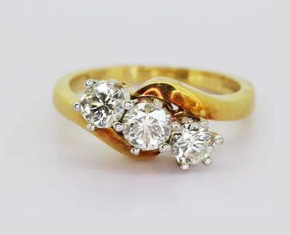 Vintage 1.30ct Diamond Three Stone Crossover Ring; claw set in 18ct white gold, on 18ct yellow gold shank. Total diamond weight estimated to be 1.30 carats.