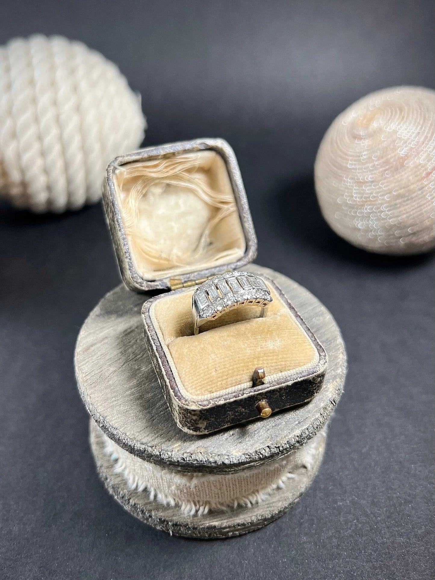 A three row diamond band ring in platinum in an antique ring box