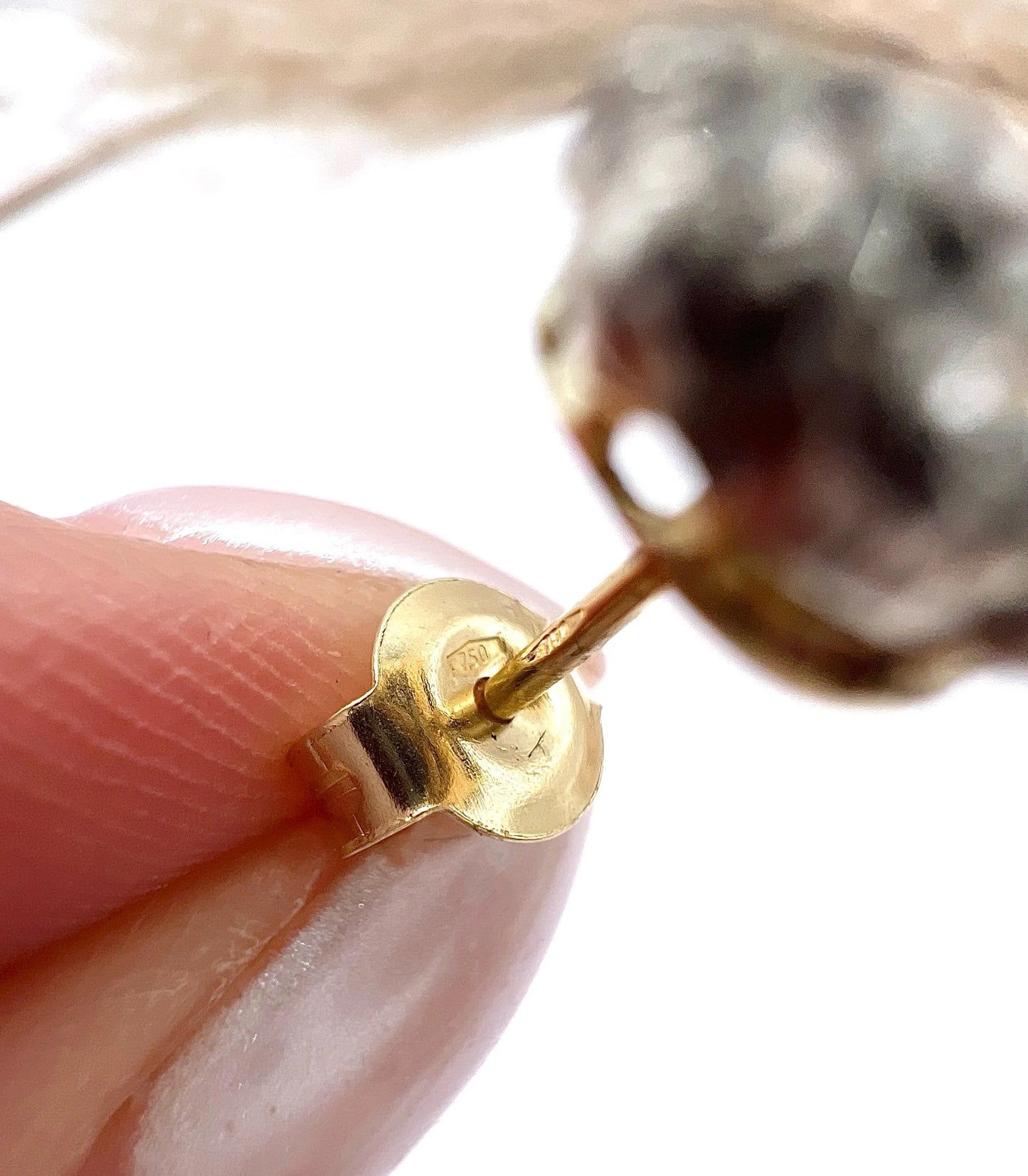 Close-up of 750 stamps on a gold earring