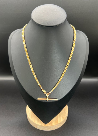 A yellow gold curb link Albert watch chain, on a black jewellery bust