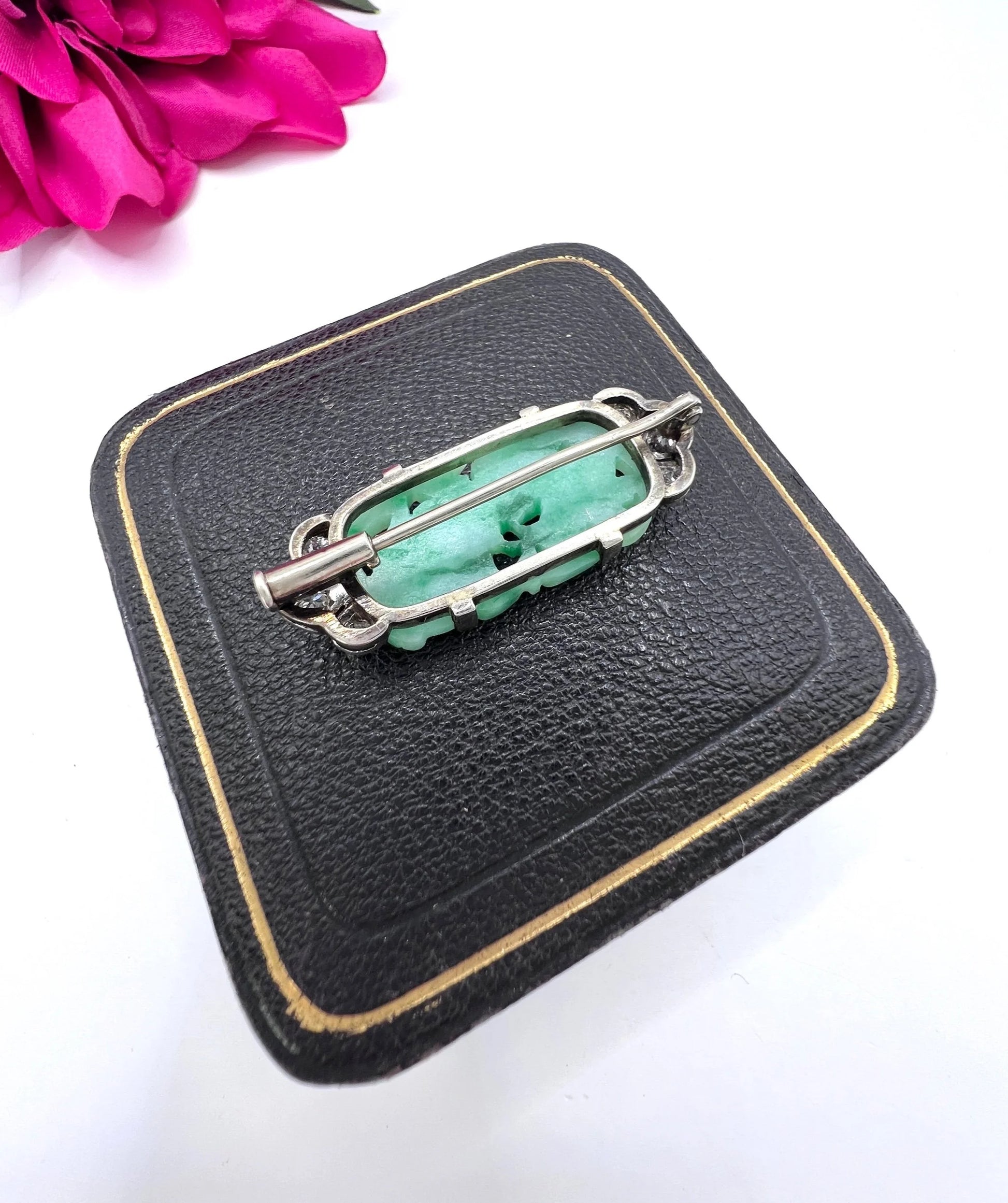A carved green jade and diamond brooch in white gold
