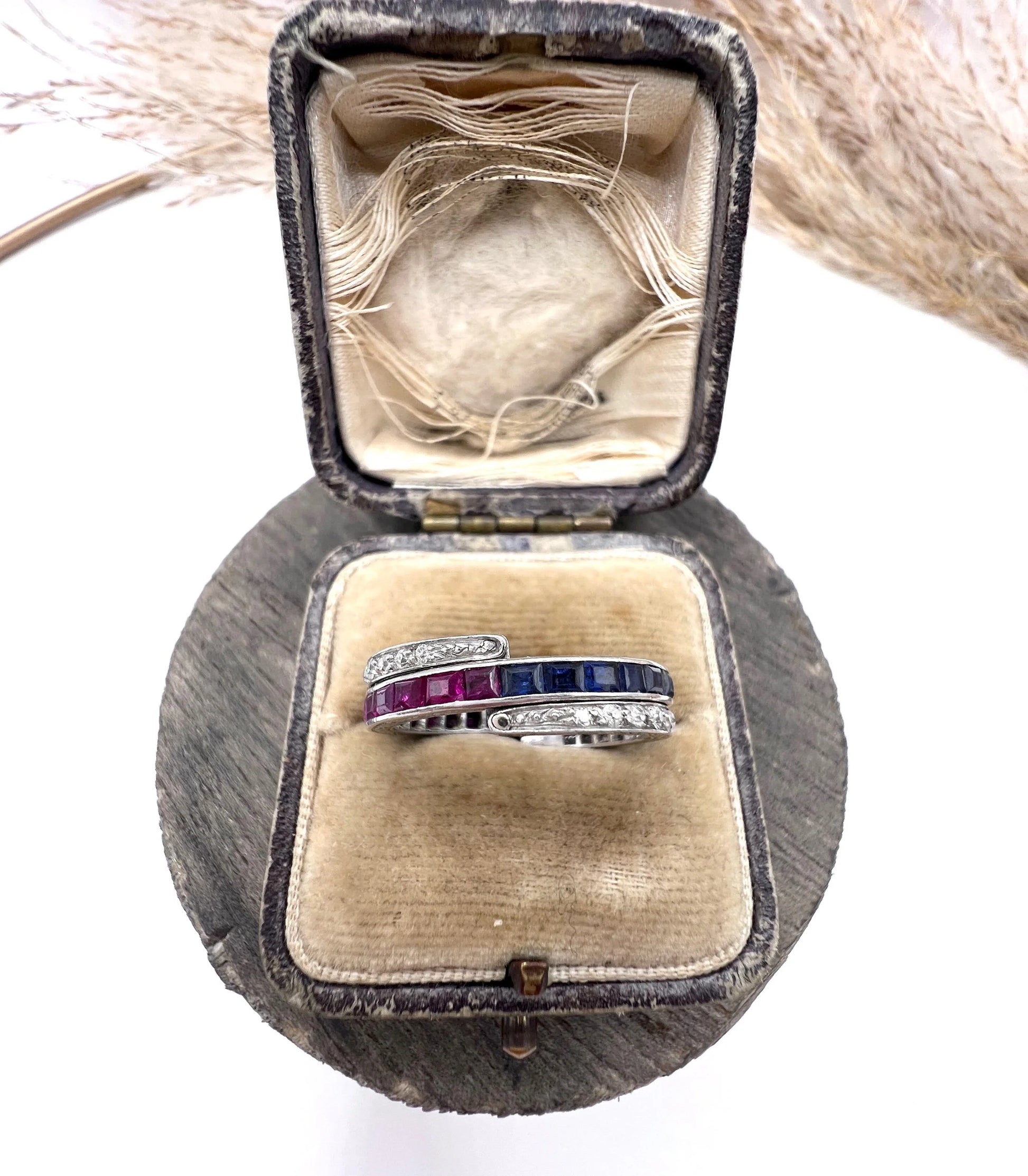 A platinum night and day flip band ring set with diamonds, sapphires and rubies, in a ring box