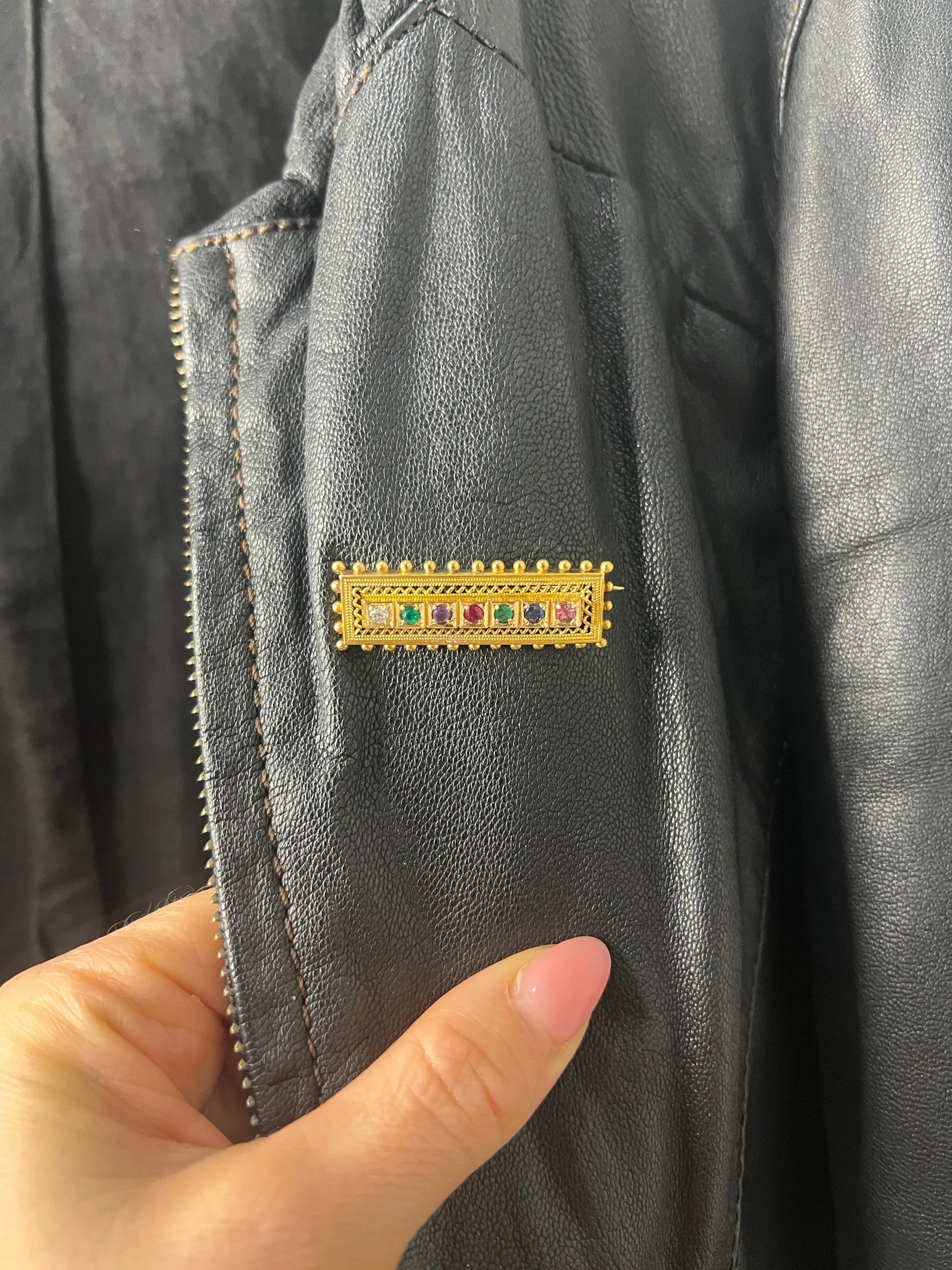 A yellow gold multi-gemstone and diamond acrostic brooch, modelled on a black jacket