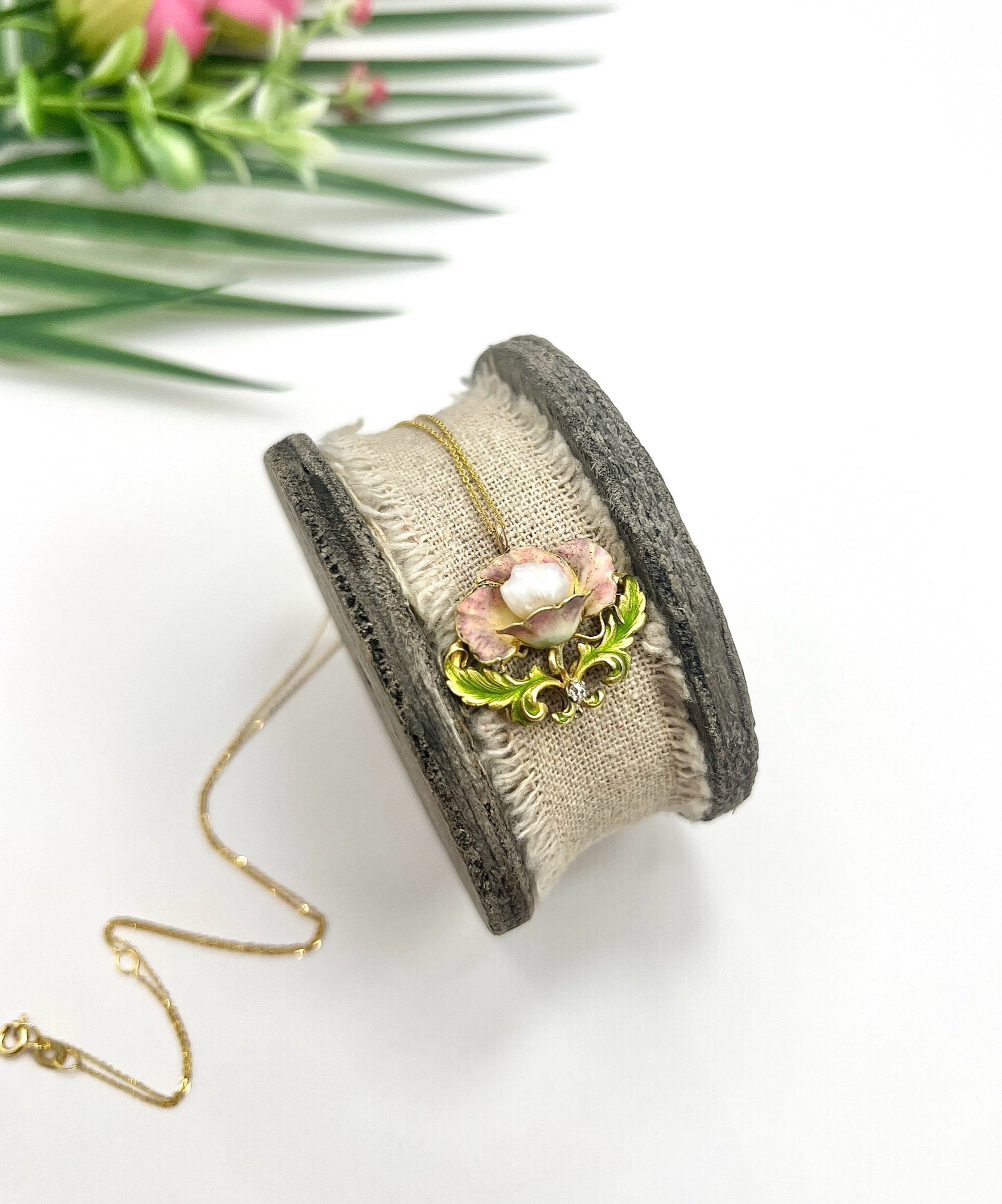 An enamel, diamond and pearl flower pendant with a gold chain