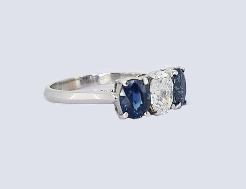 Sapphire and Diamond Three Stone Ring, classic trilogy ring featuring, 0.75ct oval-cut diamond flanked by 1.75cts oval sapphires, claw set, 18ct white gold.