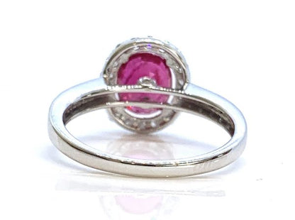 Ruby and Diamond Halo Cluster Engagement Ring; 1.71ct oval ruby with no indication of heat treatment with diamond halo and diamond shoulders, 18ct white gold