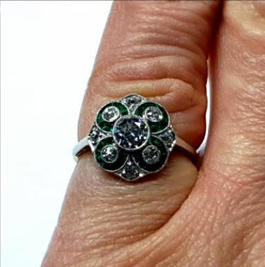 Antique Edwardian Emerald and Diamond Floral Cluster Dress Ring; old European transitional cut diamonds with calibre emeralds set into circular floral swirls, 1.00 carat total, in platinum with 18ct gold engraved sides, Swedish, Circa 1900