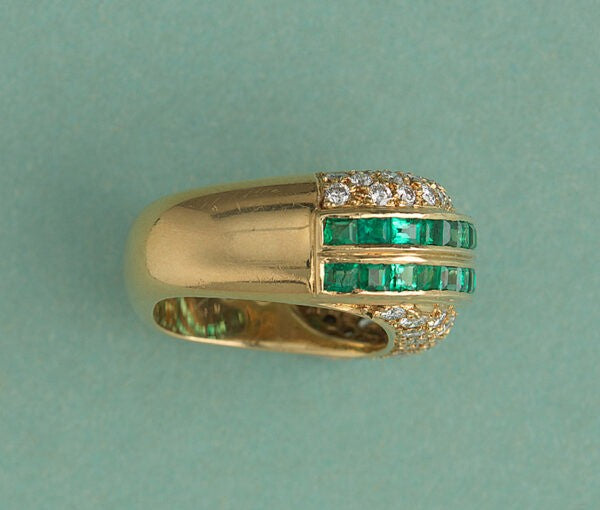 Vintage Emerald and Diamond Asymmetric Band Ring; two diagonal stripes set with 1.92cts carré cut emeralds bordered by 1.30cts graduated brilliant cut diamonds on each side, in 18ct yellow gold