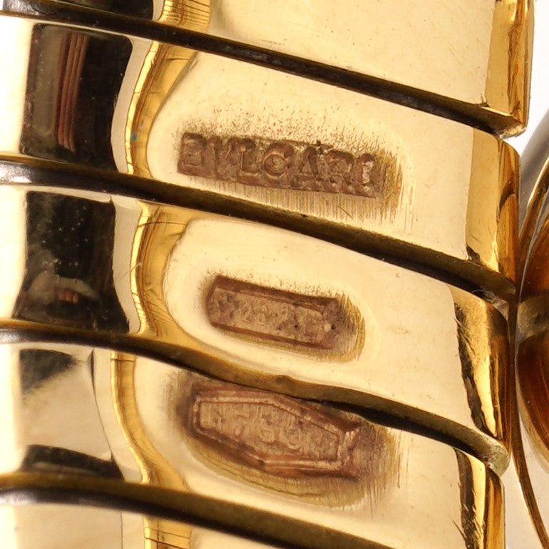 Vintage Bvlgari 18ct Yellow Gold and Onyx Tubogas Bangle Bracelet, 18ct yellow gold tubogas flexible sprung cuff made of coiled gas pipe links with terminals of circular onyx plaques encased in a polished surround engraved with the BVLGARI BVLGARI motif. Made in Italy, Alexandria, Circa 1990s