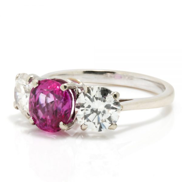 Natural Pink Sapphire and Diamond Three Stone Ring; central 1.50ct natural pink sapphire flanked by 2cts round brilliant-cut diamonds, all claw set in platinum
