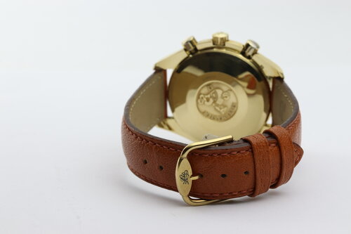 Omega Speedmaster 39mm Automatic Chronograph 18ct Yellow Gold, Silver and white baton dial, date indicator at 3, small seconds at 9, on brown leather strap.