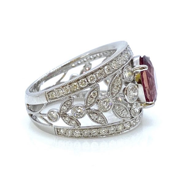 3.19ct Padparadscha Sapphire and Diamond Dress Ring by David Jerome; the central, unheated 3.19 carat oval faceted padparadscha sapphire is nestled upon a wide floral openwork band set with 1.56 carats of sparkling white diamonds, in 18ct white gold