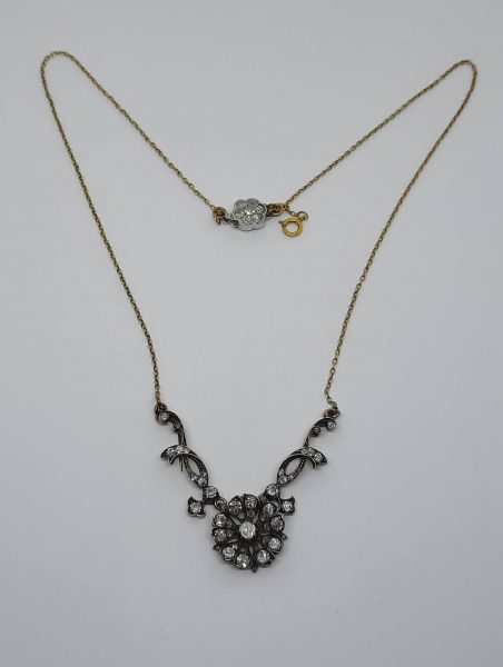 Antique Victorian Flower Cluster Necklace, 2.30 carat total, central old-cut diamond flower design is flanked by diamond-set trailing foliage to a fine chain with diamond-set clasp, in silver-upon-gold, Circa 1870