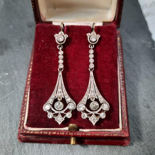 A pair of Art Deco diamond drop earrings in white metal, in a red antique earring box