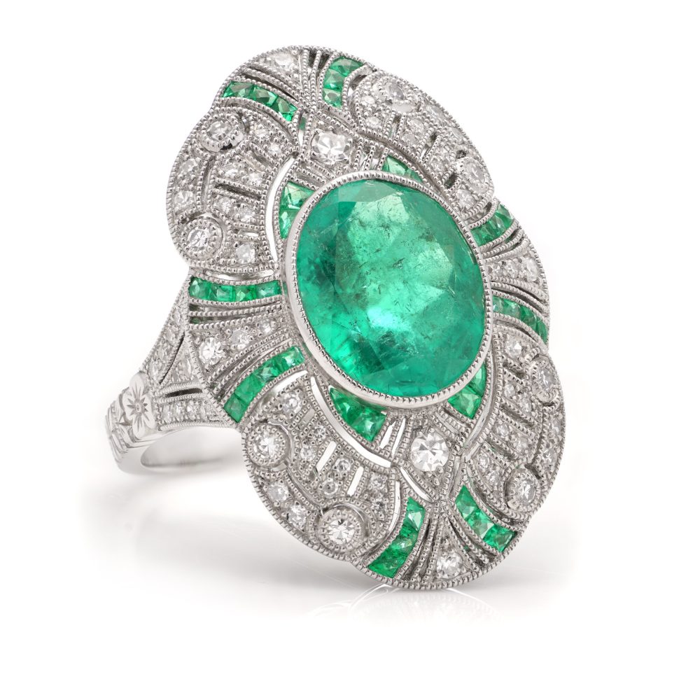 Oval cut emerald ring surround by emeralds and diamonds set in platinum.