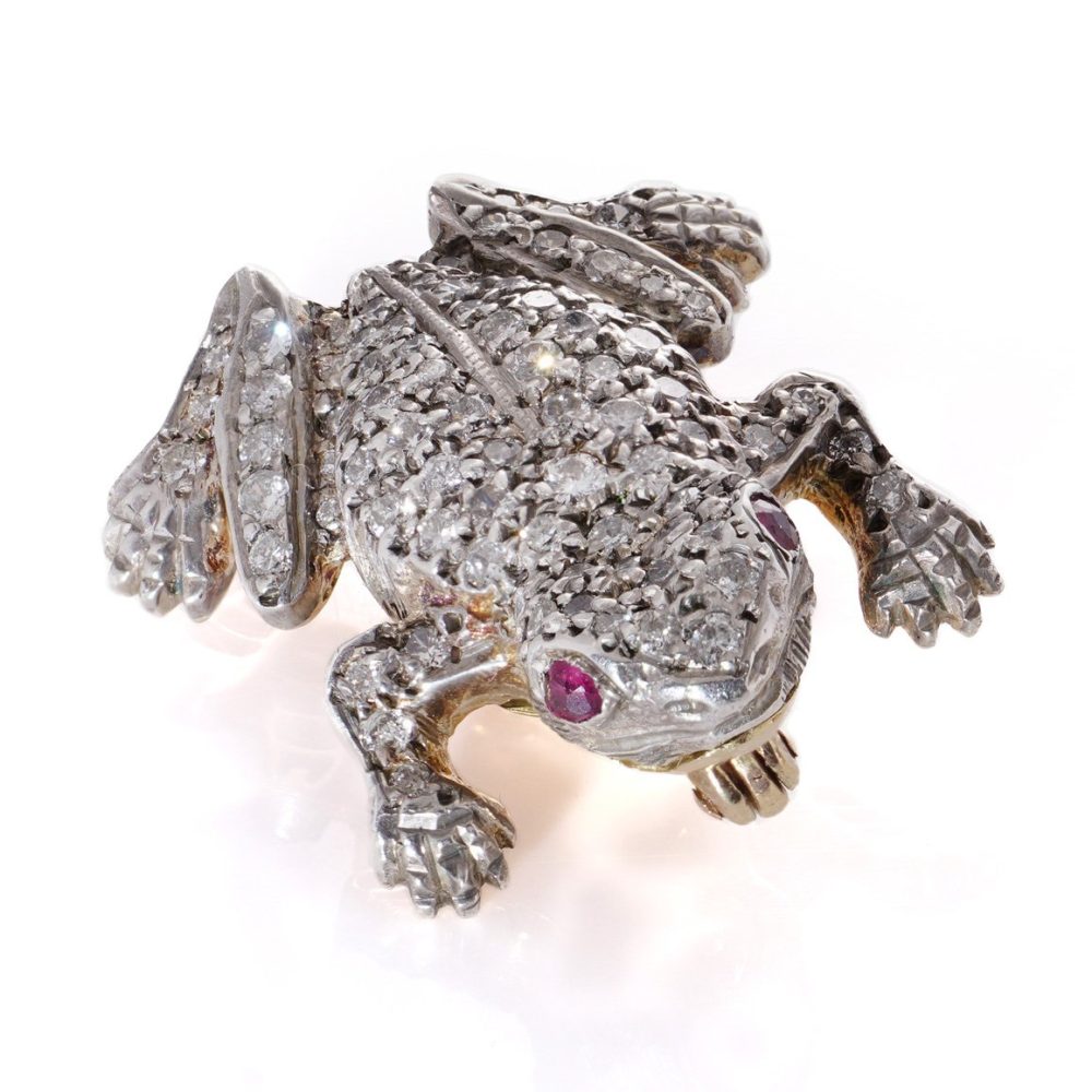 An Edwardian frog brooch in gold and silver set with diamonds and rubies.