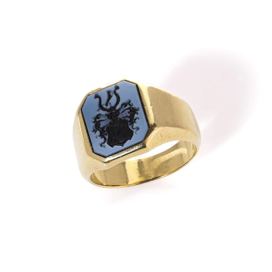 A yellow gold ring with an octagonal sardonyx intaglio, on a white background