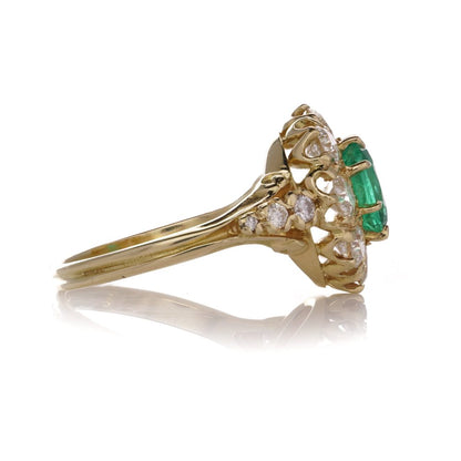 Emerald and diamond cluster ring in gold.