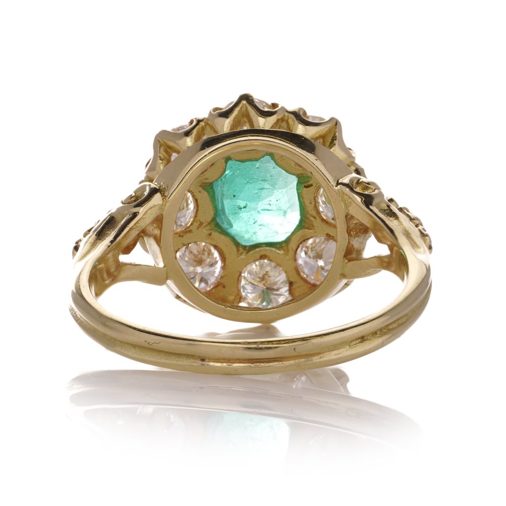 Emerald and diamond cluster ring in gold.