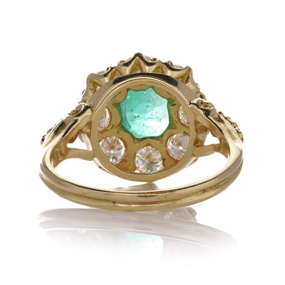 Emerald and diamond cluster ring in gold.