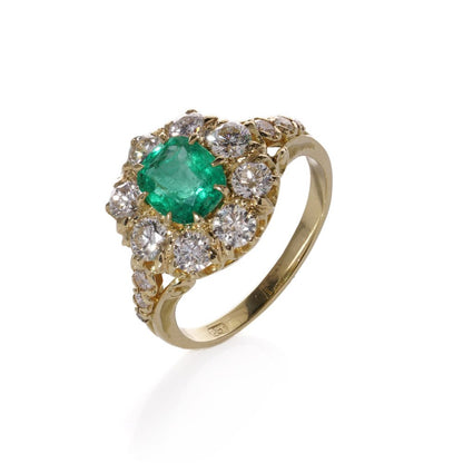 Emerald and diamond cluster ring in gold.