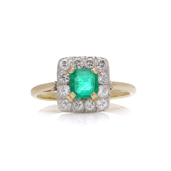 Emerald and diamond cluster ring in gold and platinum.