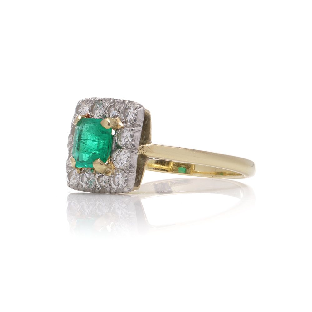 Emerald and diamond cluster ring in gold and platinum.