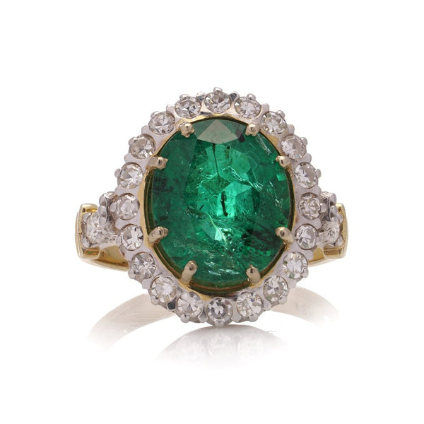 Emerald and diamond cluster ring in gold.