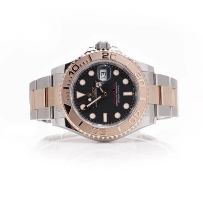 A Rolex Yacht-Master black dial wristwatch in steel and rose gold, on a white background