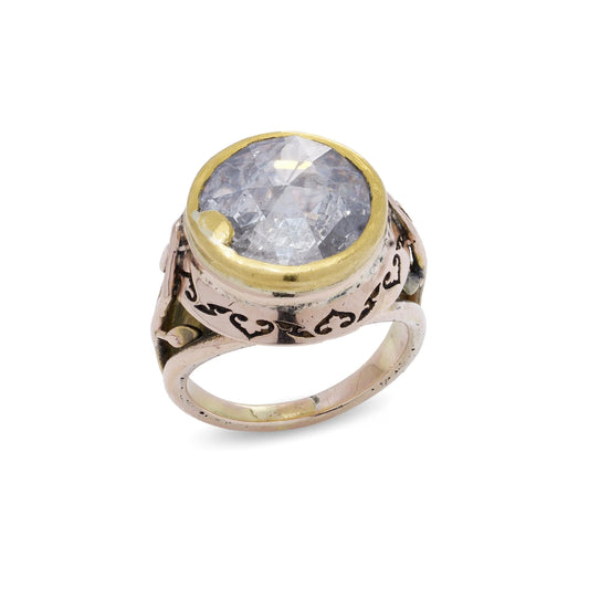 A large solitaire rose cut diamond ring in yellow and rose gold with decorative gallery and shank, on a white background