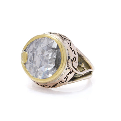A large solitaire rose cut diamond ring in yellow and rose gold with decorative gallery and shank, on a white background